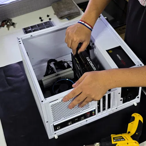 Técnico da Litoral Place instalando uma placa de vídeo em um gabinete branco